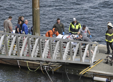 Emergency response crews transport an injured passenger to an ambulance