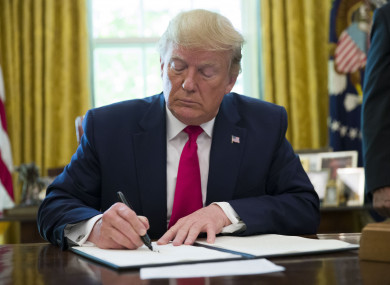 President Donald Trump signs an executive order to increase sanctions on Iran, in the Oval Office of the White House.