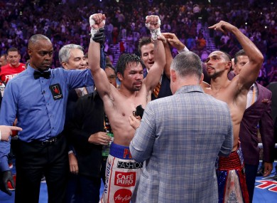 Referee Kenny Bayless holds up Pacquiao's hand as he is declared the winner by split decision.