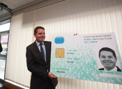 Paschal Donohoe holds up a mock-up of a PSC after he registered for one. August, 2016.