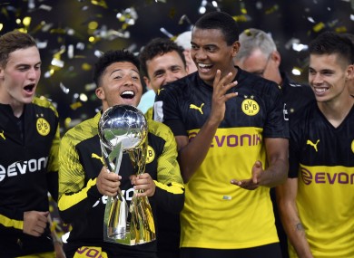 Jadon Sancho celebrates with the trophy.
