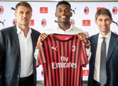 Leao holding up the jersey with (left) technical director Paolo Maldini.