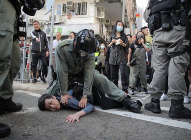 A protester is detained by police in Hong Kong.