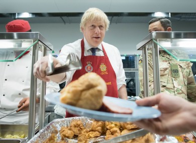 Johnson serves Christmas lunch to British troops stationed in Estonia during a one-day visit to the Baltic country.