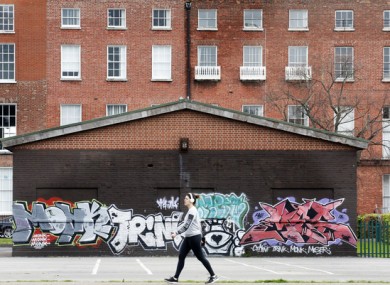 A woman walks through Mountjoy Square.