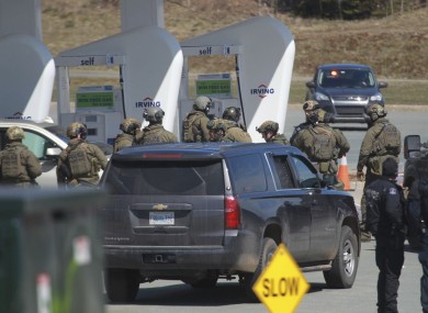 Royal Canadian Mounted Police officers prepare to take a person into custody at a gas station in Enfield, Nova Scotia.