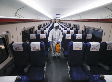 A staff member disinfects the interior of a train at a depot in Wuhan, China yesterday in preparation for today.