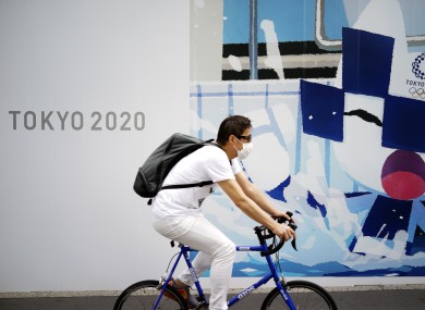 A man in Tokyo last week riding a bicycle in front of an advertisement of Tokyo 2020 Olympic Games.