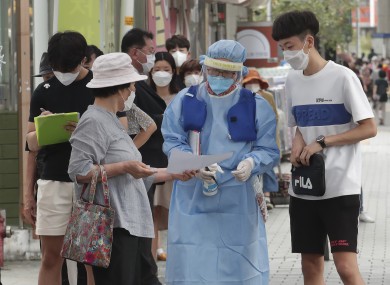 A medical worker guides people during the Covid-19 testing at a makeshift clinic in Seoul