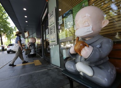 A Buddhist monk doll wearing a face mask is displayed near the Chogyesa temple in Seoul