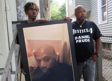 Joe Prude, uncle of Daniel Prude, right, and Daniel's nephew Armin, stand with a picture of Daniel Prude in Rochester New York yesterday.