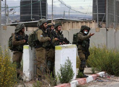 Israeli security forces stand guard at the scene where a Palestinian man was killed by Israeli soldiers near the West Bank city of Nablu today.