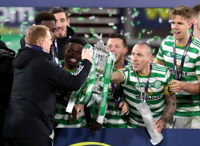 Celtic manager Neil Lennon takes the trophy from Scott Brown (right).