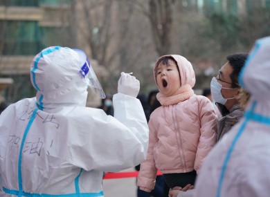 A medical worker collects a swab sample from a girl at a community in Qiaoxi District of Shijiazhuang