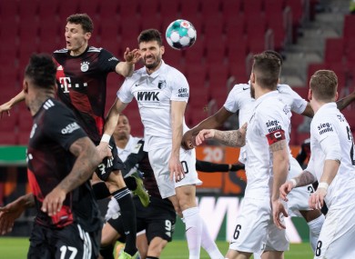 Bayern Munich's Benjamin Pavard and Daniel Caligiuri of Augsburg contesting for the ball.