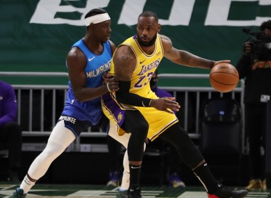 Lakers forward LeBron James is defended by Milwaukee Bucks guard Jrue Holiday.