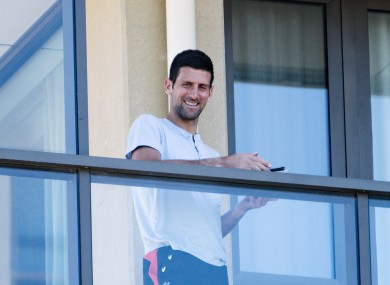 Novak Djokovic pictured yesterday on the balcony at The M Suites accommodation in North Adelaide, Australia.
