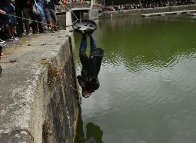 The statue being thrown into Bristol harbour last year.