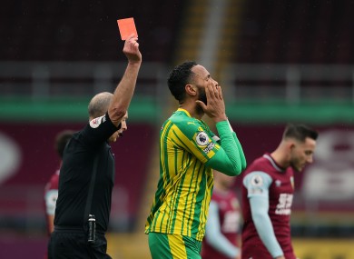 Referee Mike Dean shows a red card.
