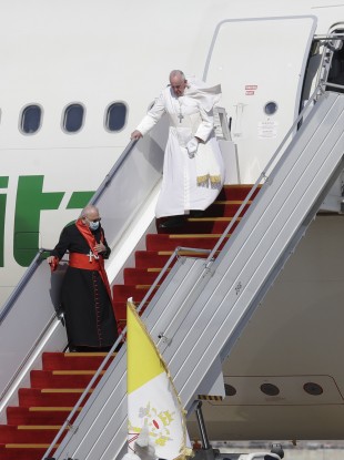Pope Francis walks down the steps of an airplane as he arrives at Baghdad international airport, Iraq