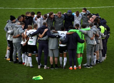 Swansea City players and staff in a huddle in the aftermath of a recent Championship fixture.