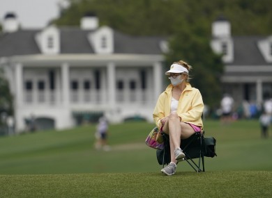 A masked spectator watches on at Augusta.