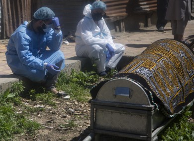 Relatives mourn near a coffin containing the body of a person who died of Covid-19 in Srinagar, India, today.