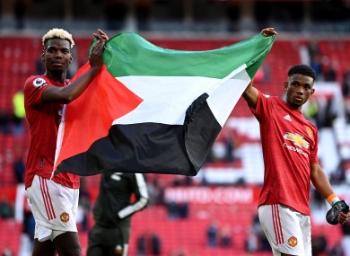 Manchester United's Paul Pogba (left) and Amad Diallo hold up the flag of Palestine.