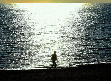 A woman walks on the beach in Marbella, Andalusia.