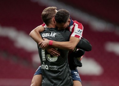 Atletico Madrid's goalkeeper Jan Oblak, left, embraces his teammate Renan Lodi.