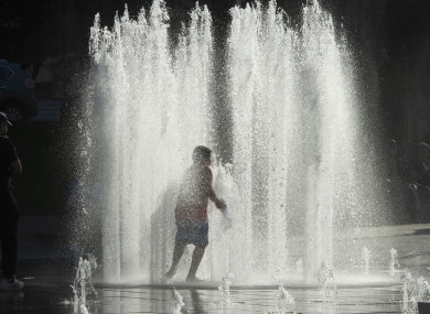 A boy beats the heat as he plays in a fountain.