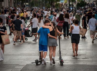 A couple wearing face masks kiss by Portal del Angel shopping street in Barcelona
