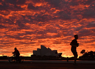 A jogger runs past the Sydney Opera House at dawn (Mick Tsikas/AAP Image via AP)