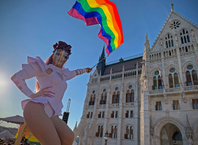 An unidentified drag queen waves a rainbow flag during an LGBT rights demonstration in front of the Hungarian Parliament building in Budapest (Bela Szandelszky/AP)