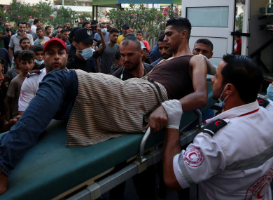 Medics tend to a youth who was shot in the leg by Israeli troops during a protest at the Gaza Strip’s border with Israel.