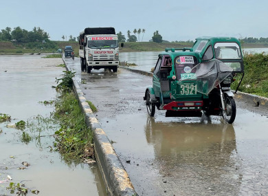Motorists cross a bridge as the river starts to swell due to approaching typhoon Chanthu in Cauayan, northern Philippines.