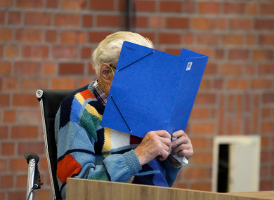The accused Josef S covers his face as he sits at the court room in Brandenburg, Germany