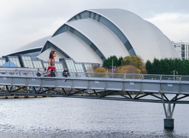 Puppet Little Amal walks across the River Clyde in Glasgow in front of where the COP26 summit is being held