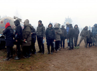 Migrants queue to get some water in a tent camp on the Belarusian-Polish border today.