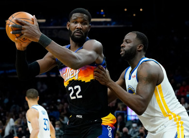 Phoenix Suns centre Deandre Ayton (22) backs down Golden State Warriors forward Draymond Green.