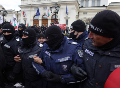 Police officers try to keep protesters away from the Bulgarian Parliament building in Sofia