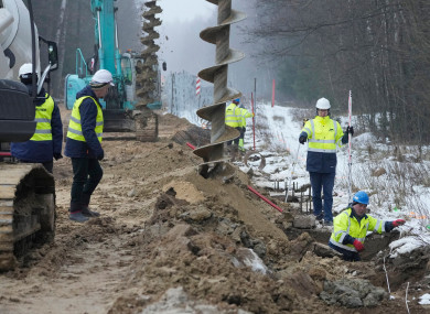 Workers and heavy machinery working on the first part of a metal wall in Tolcze, near Kuznica, Poland on the Polish side of the border with Belarus.