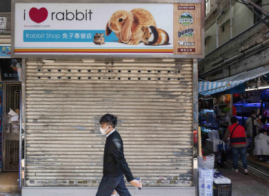 A pedestrian walks past a closed pet shop which sells hamsters in Hong Kong.