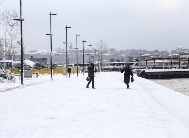 Two women take pictures on the coastal road in the Golden Horn in Istanbul, where heavy snowfall continues