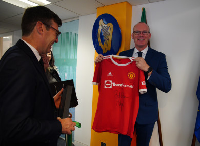 Simon Coveney being presented with a signed Denis Irwin Manchester United FC shirt by Andy Burnham in October 2021.
