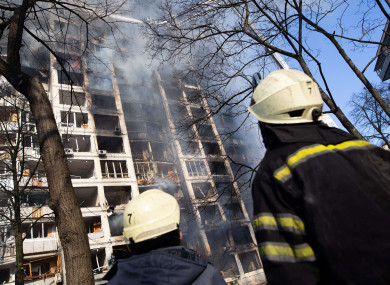Firemen at a fire that broke out in an apartment building hit by shelling in Kyiv today.