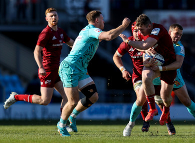 Munster's Chris Farrell is tackled by Sam Simmonds and Joe Simmonds.