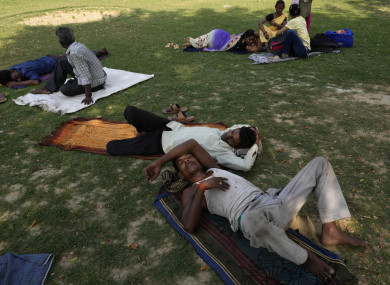 Indian people sleep under the shade of a tree on a hot afternoon in the central Indian state of Uttar Pradesh.