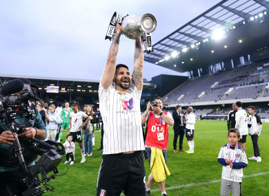 Fulham's Aleksandar Mitrovic celebrates with the Championship trophy.