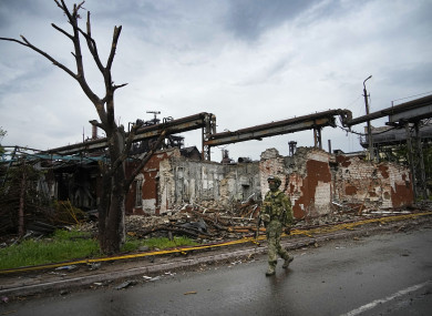 A Russian soldier patrols a destroyed part of the Illich Iron & Steel Works Metallurgical Plant in Mariupol.